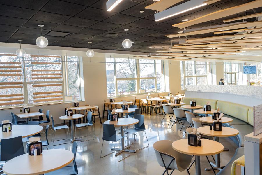 Wide view of a seating area in the Eastway Dining Hall, showing mostly tables but also a few booth options