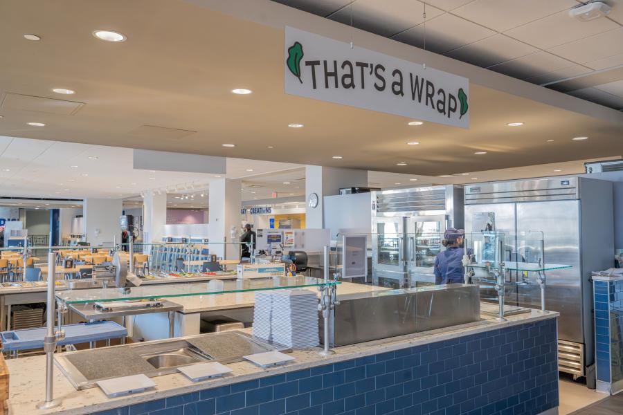 View of Eastway's "That's a Wrap" area, featuring a prep counter, storage cooler, and stacks of plates