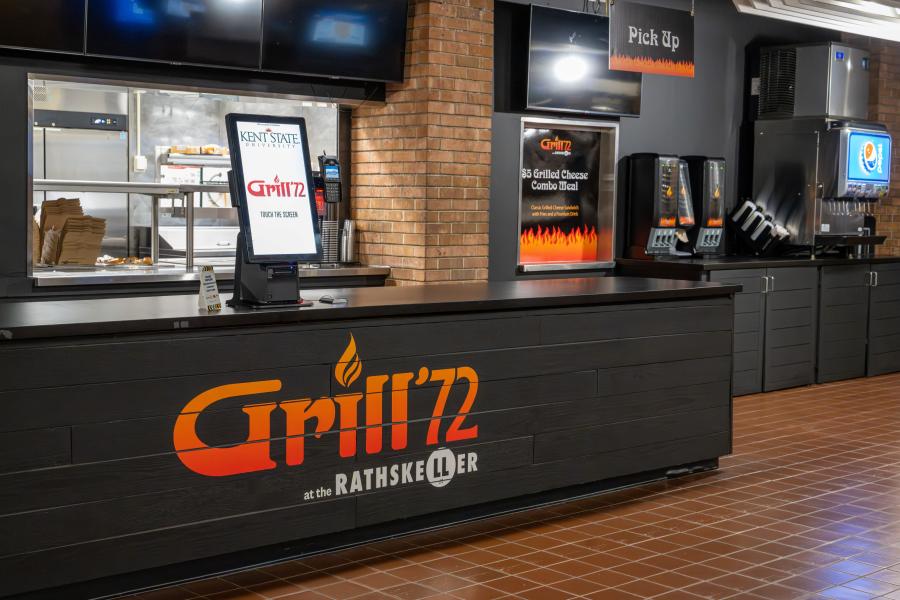 Angled view of the order and pick up counter at Grill '72 with the condiments and fountain drink station to the far right