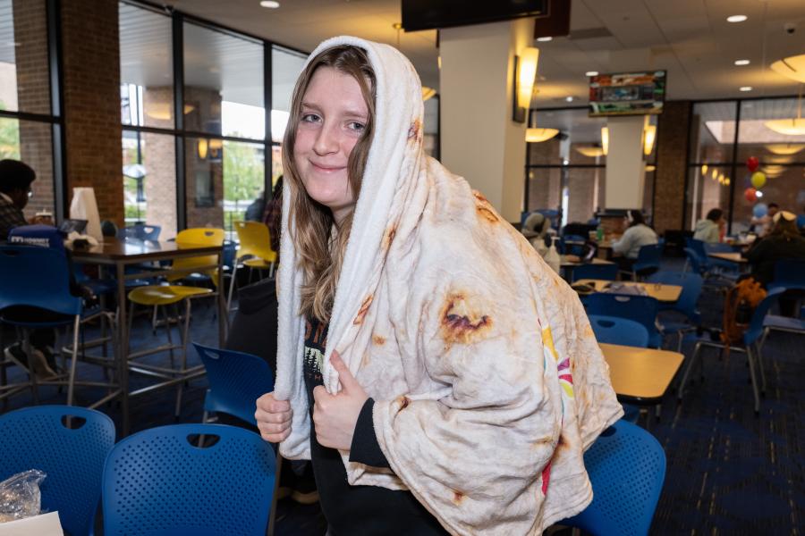 student wearing a burrito blanket