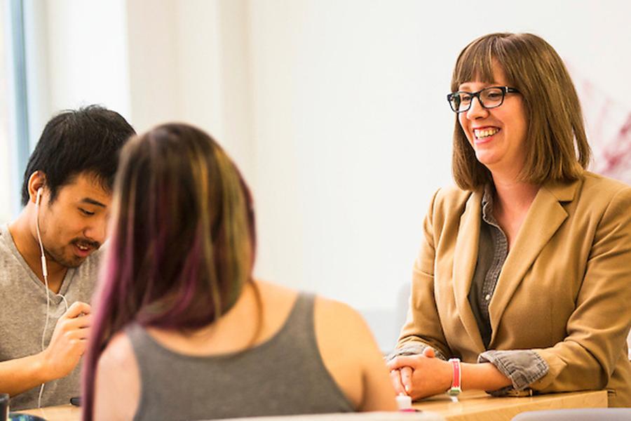 Instructor at desks talking with several students