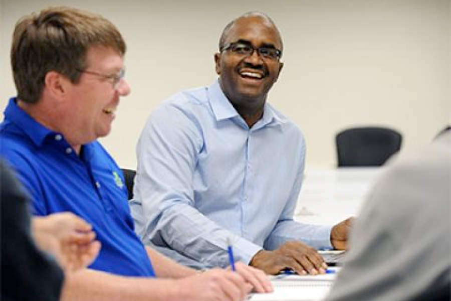 Two program attendees laugh and discuss.