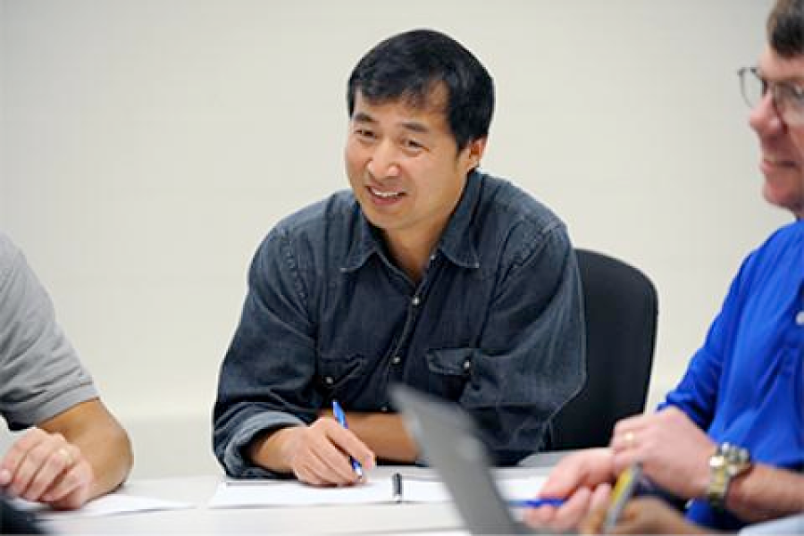 A smiling program participant takes notes.
