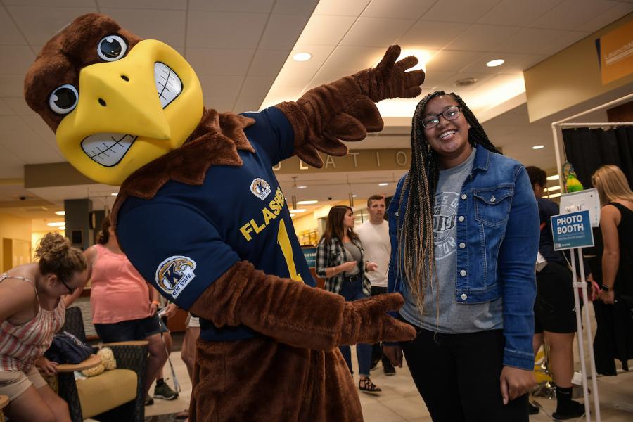 Flash poses for a picture with a student.