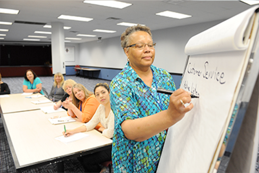 A program participant writes on a large paper pad