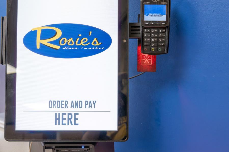 Close up of an order kiosk with payment device at Rosie's Diner, where students submit and pay for their food order