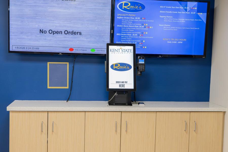 Close up of the Tri Deli order station, including a menu screen, an order tracking screen, and an ordering kiosk