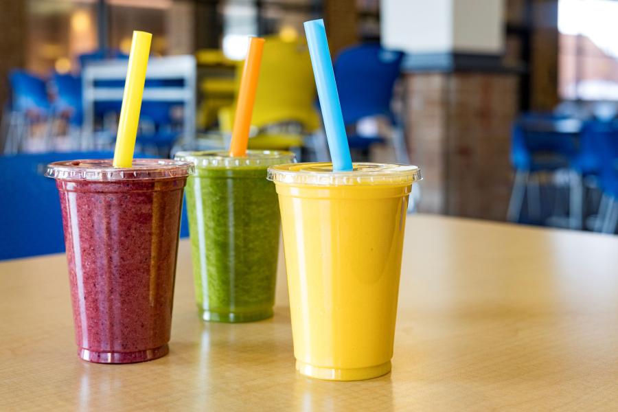 Three smoothies from Recharge, each a different flavor and color, sitting on a table in the KSC Hub