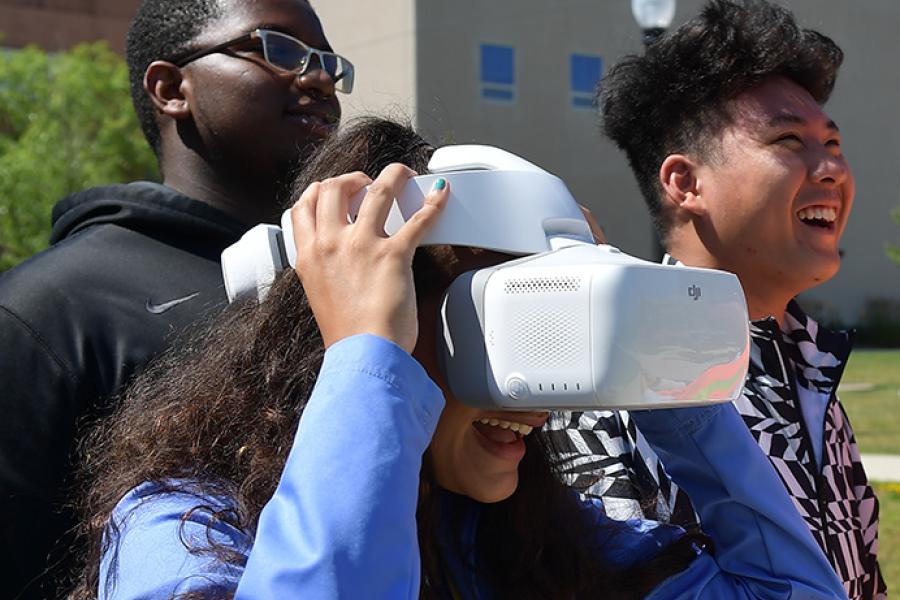 A student observes a drone's flight through a video headset