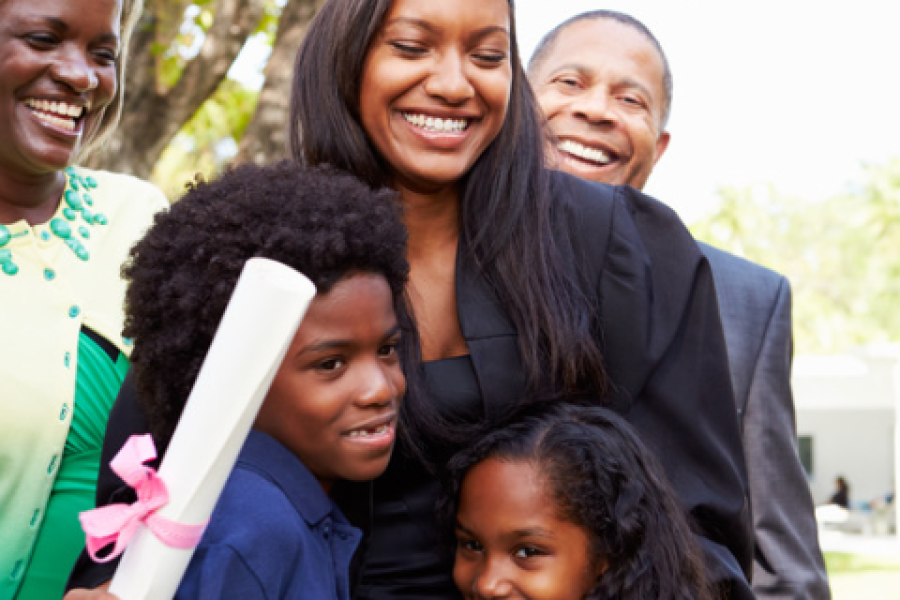 A woman graduate hugs young children