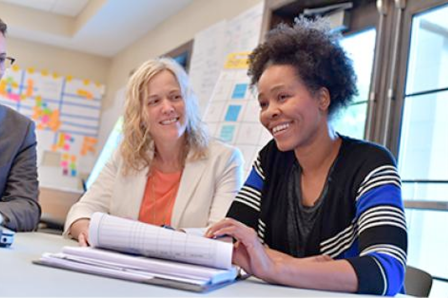 Two smiling participants work through a packet