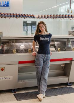 Adelynn Prushing stands in a studio for a photo.