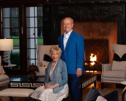 a couple poses together in front of a lit fireplace