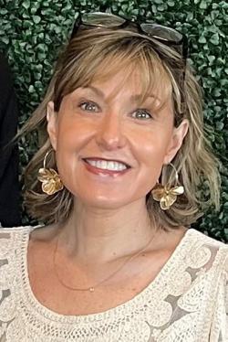 Woman with brown hair and tan top