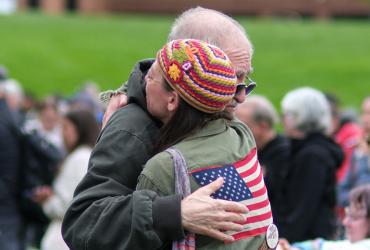 Friends hug while members of the Kent State University community and visitors gather on the Kent State Commons for the annual May 4 Commemoration to honor those who were killed and wounded on May 4, 1970. (Photo credit: Bob Christy, Kent State University)