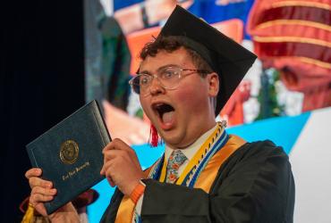 A new Kent State University graduate celebrates after receiving his diploma during the spring 2025 commencement ceremony. (Photo credit: Bob Christy, Kent State University)