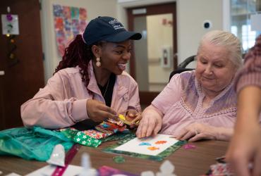 Kent State Ph.D. student Adedayo Adeagbo (left) with a resident at Tamarack Ridge