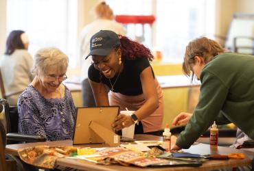Adedayo Adeagbo (center) volunteering to help older adults at the Tamarack Ridge facility