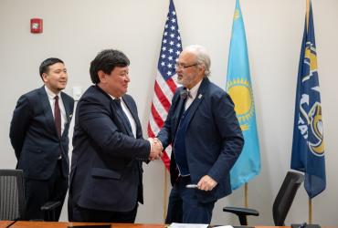 President Todd Diacon shakes hands with Kairat Zhakupov, acting chairman of the board and president of the Civil Aviation Academy, after signing an agreement for an aeronautics collaboration.