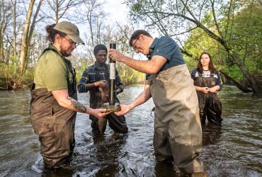Professor Dave Costello works with biology students in the Cuyahoga River