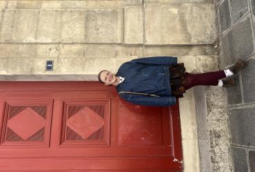 Sophia standing in front of a red door and posing for a photo. 