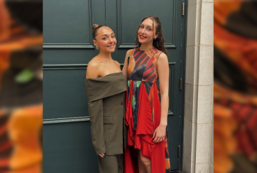 photo of two women posing in front of a door