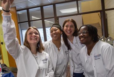 A group of young women pose for a selfie after the White Coat Ceremony.
