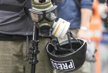Press helmet and gas mask with two presumed journalists
