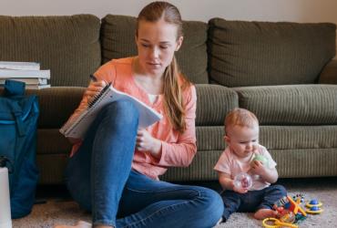 Young woman studying with baby
