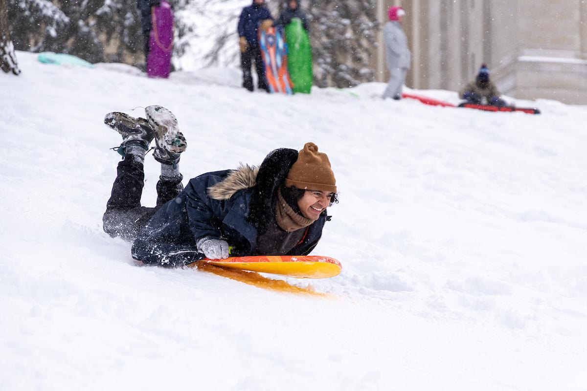 Student riding a sled on Front Campus.