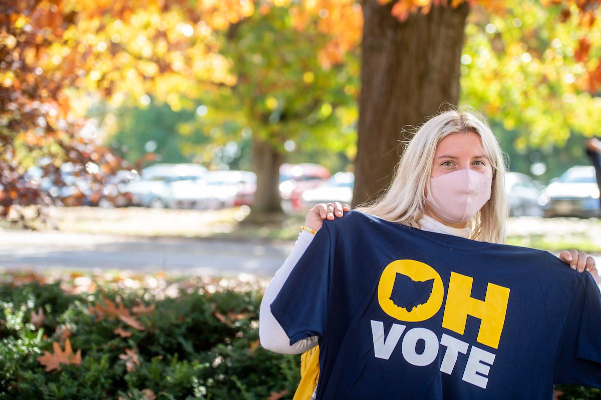 A 91PORNA student holds up the vote T-shirt she received from the university.