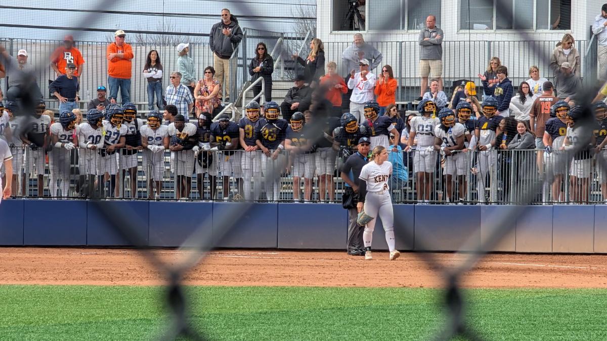 Football team supporting softball team.