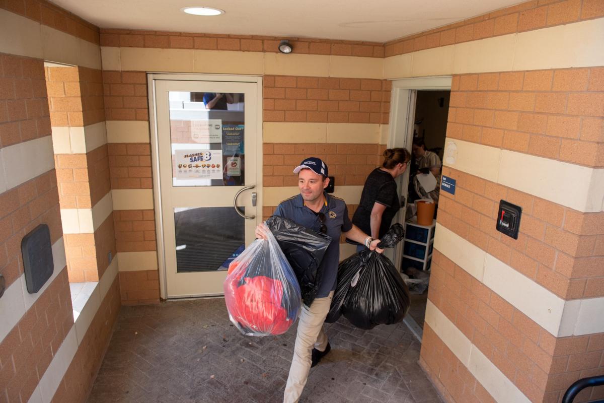 John Hummel, assistant director of safety and security for University Housing, helps to load bags of clothing donations for Family and Community Services of Ravenna.