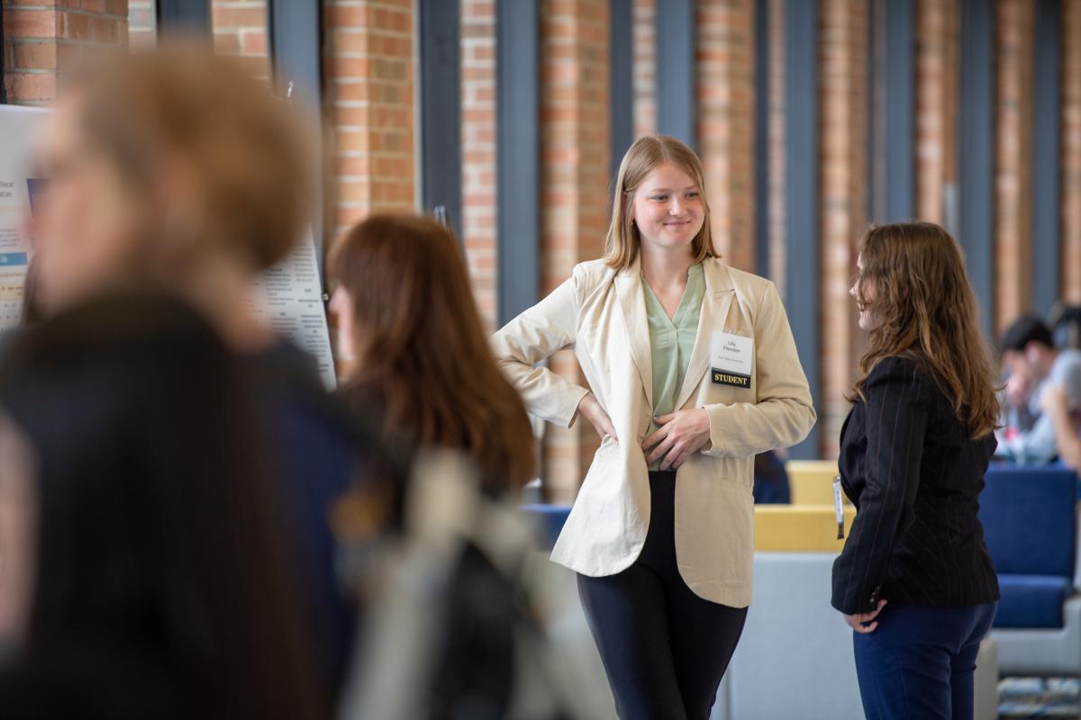 Two students talk wearing formal attire