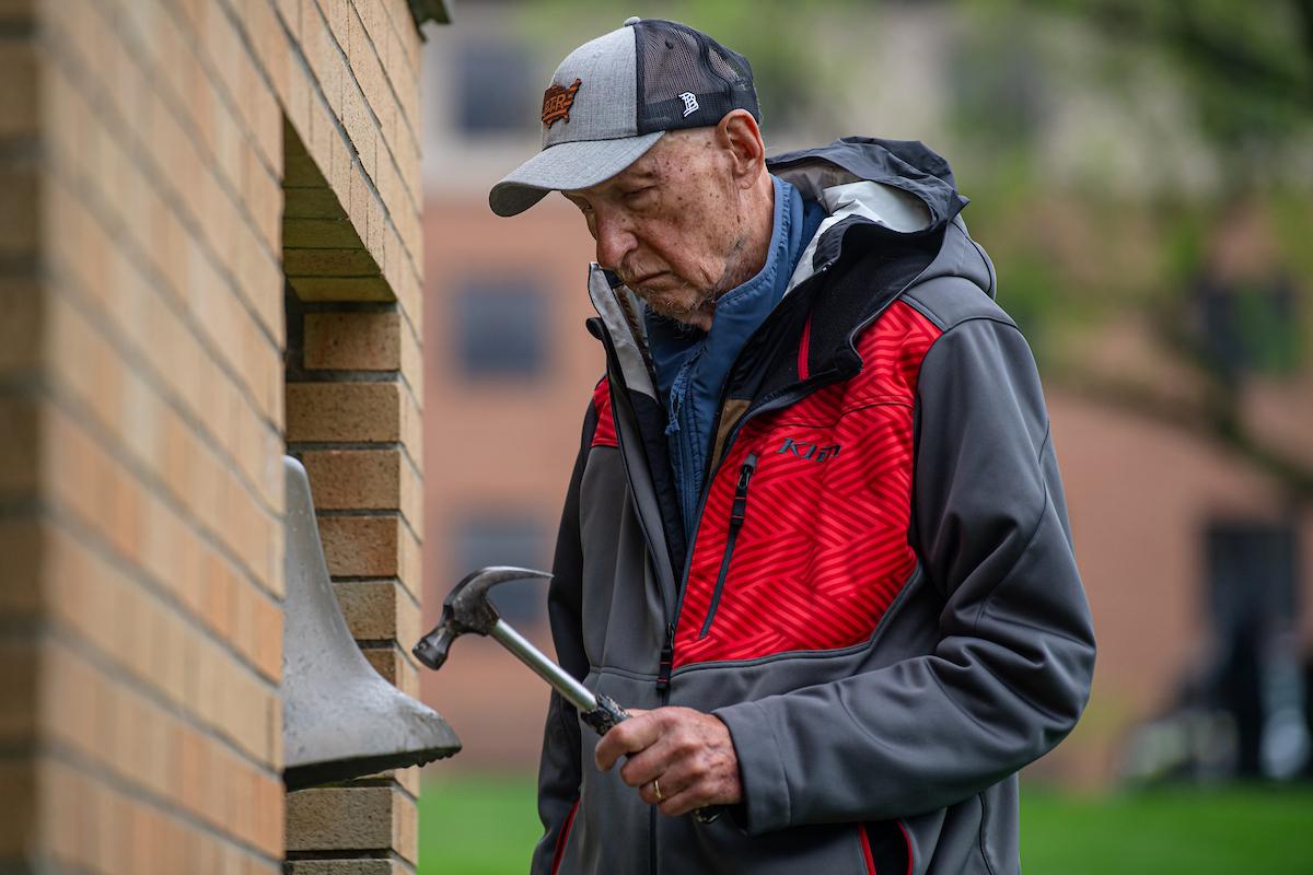 John Cleary, who was shot and wounded on May 4, 1970, at �Ը������� University, rings the Victory Bell during the May 4 Commemoration in 2025. Cleary died in October 2025. (Photo credit: Matthew Brown, �Ը������� University)