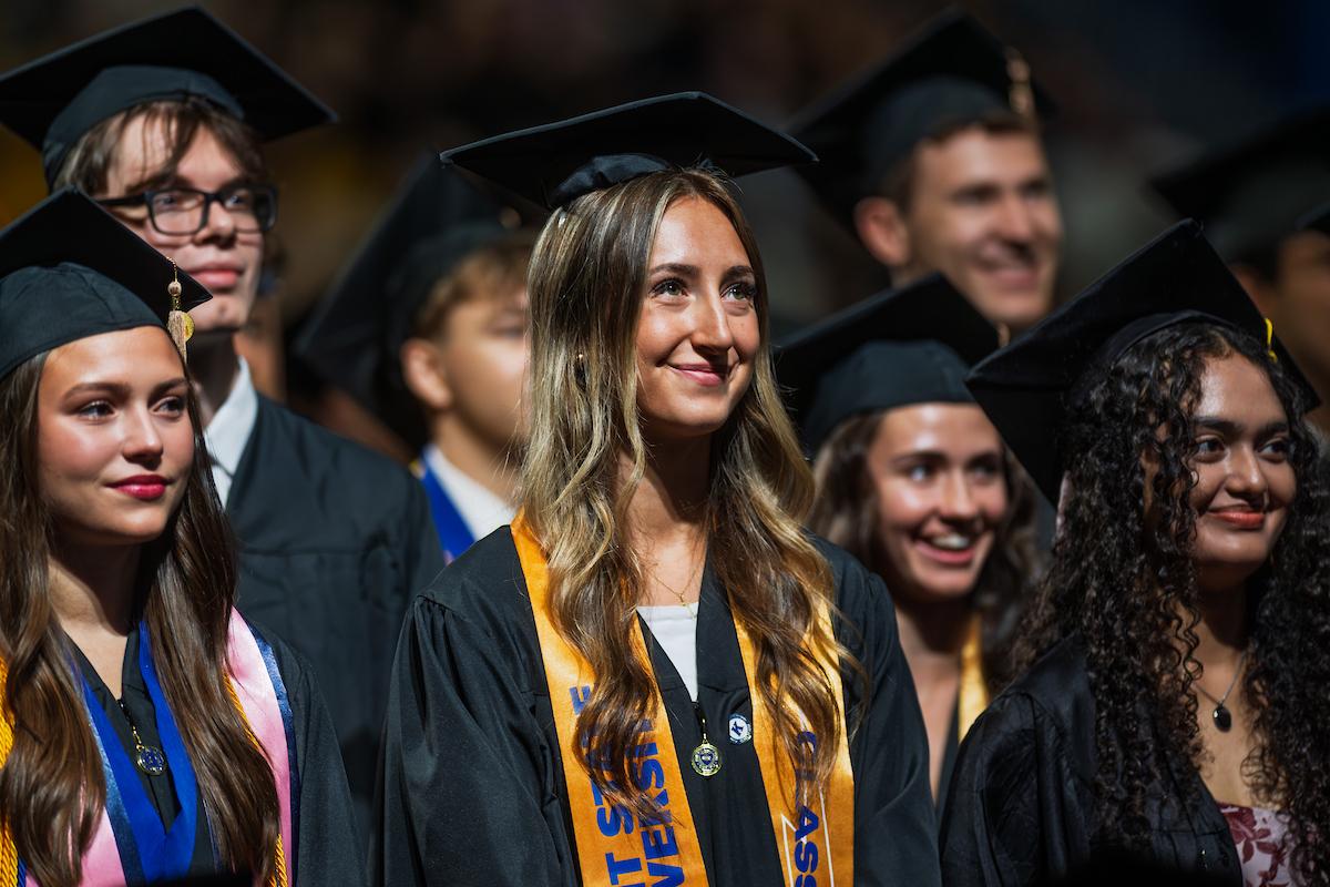 New 51�Թ��� graduates smile as they stand during their summer 2025 commencement ceremony. (Photo credit: Rami Daud, 51�Թ���)