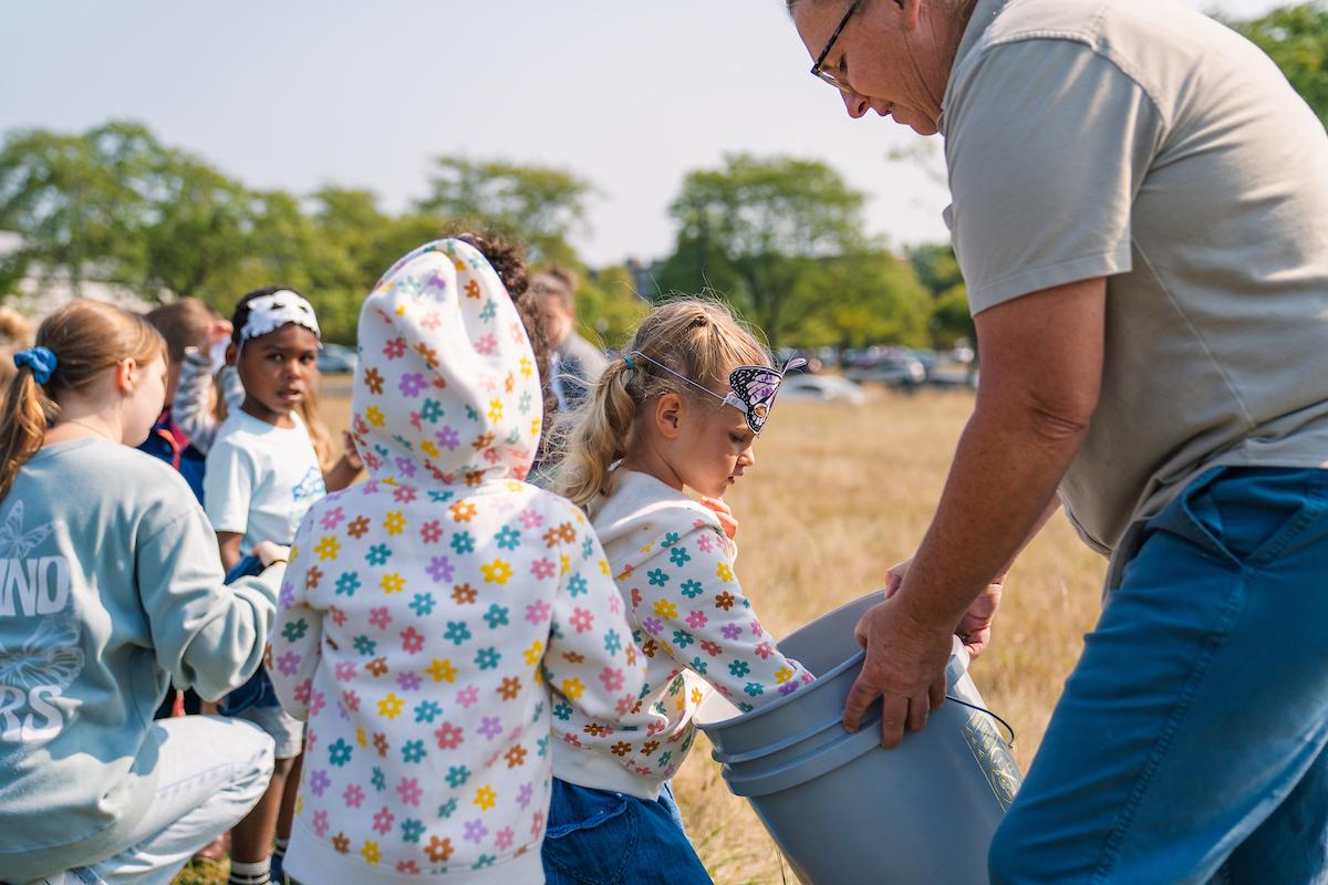 Bekkah Berryhill helping a group of children plant trees.