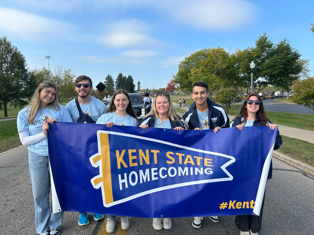 Arslan and other students holding the sign for �Ը������� Homecoming.