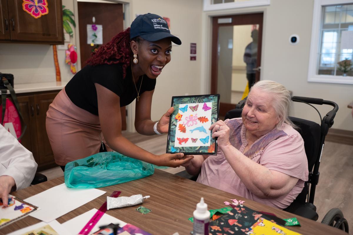 Adedayo Adeagbo (left) volunteering to help older adults at the Tamarack Ridge facility