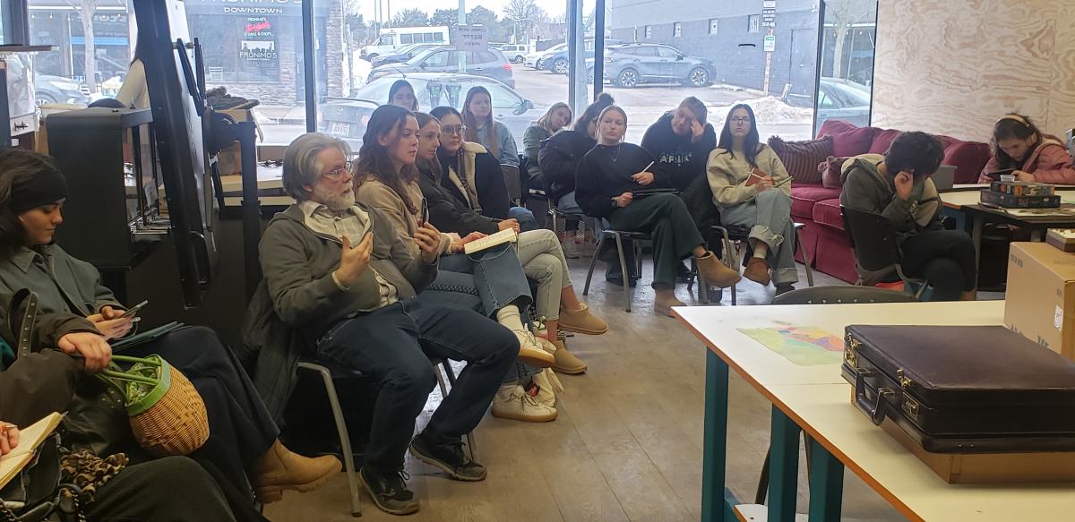 Associate Professor Bill Willoughby and his interior design students listen as students describe their artwork.