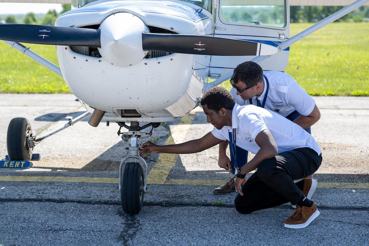 Henry Kenny Hagenimana (left), a �Ը������� student from Rwanda, and his flight instructor check the front wheel of a Cessna aircraft before Hagenimana's first flight. (Photo credit: Bob Christy)