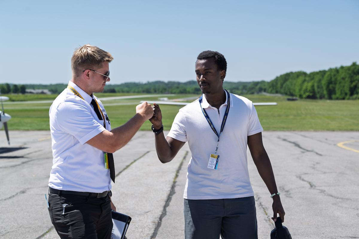 Cedric Hindura (right), a �Ը������� student from Rwanda, receives a fist bump from his flight instructor after Hindura makes his first flight. (Photo credit: Bob Christy)