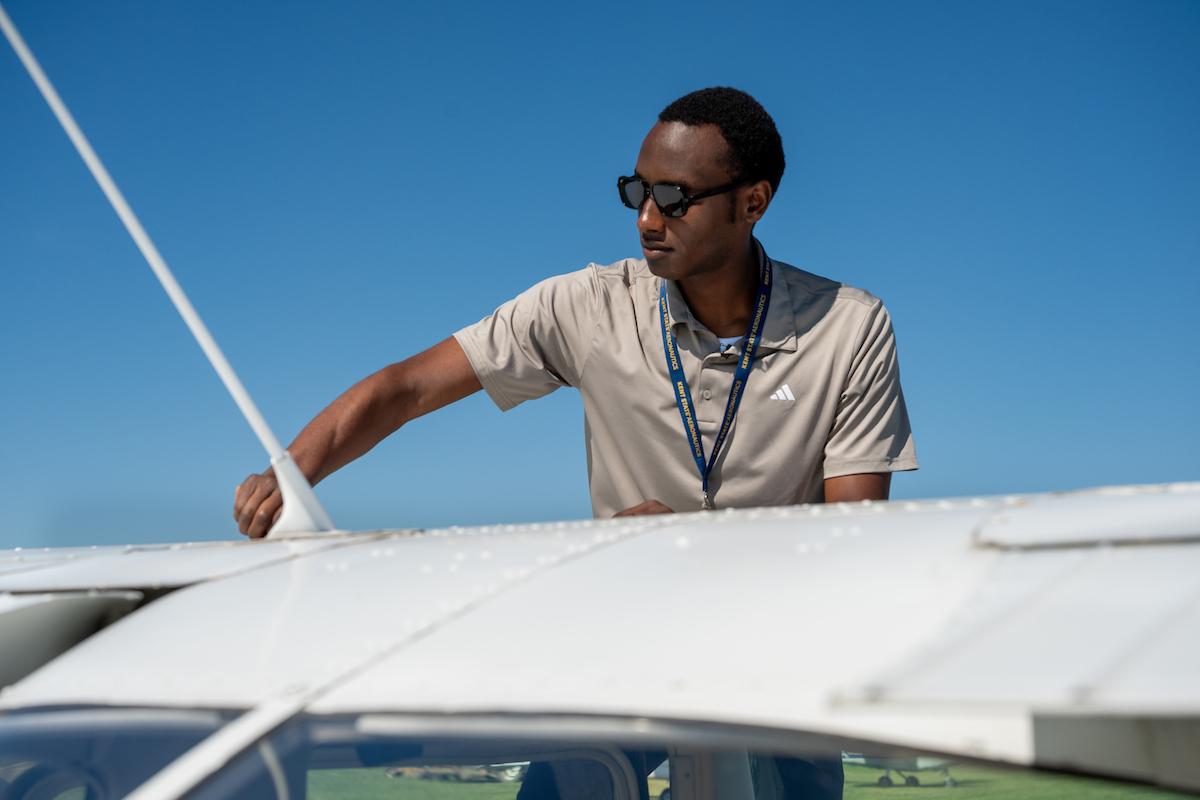 Rwandan �Ը������� student Francis Shyaka checks his plane before his first flight. (Photo credit: Bob Christy)