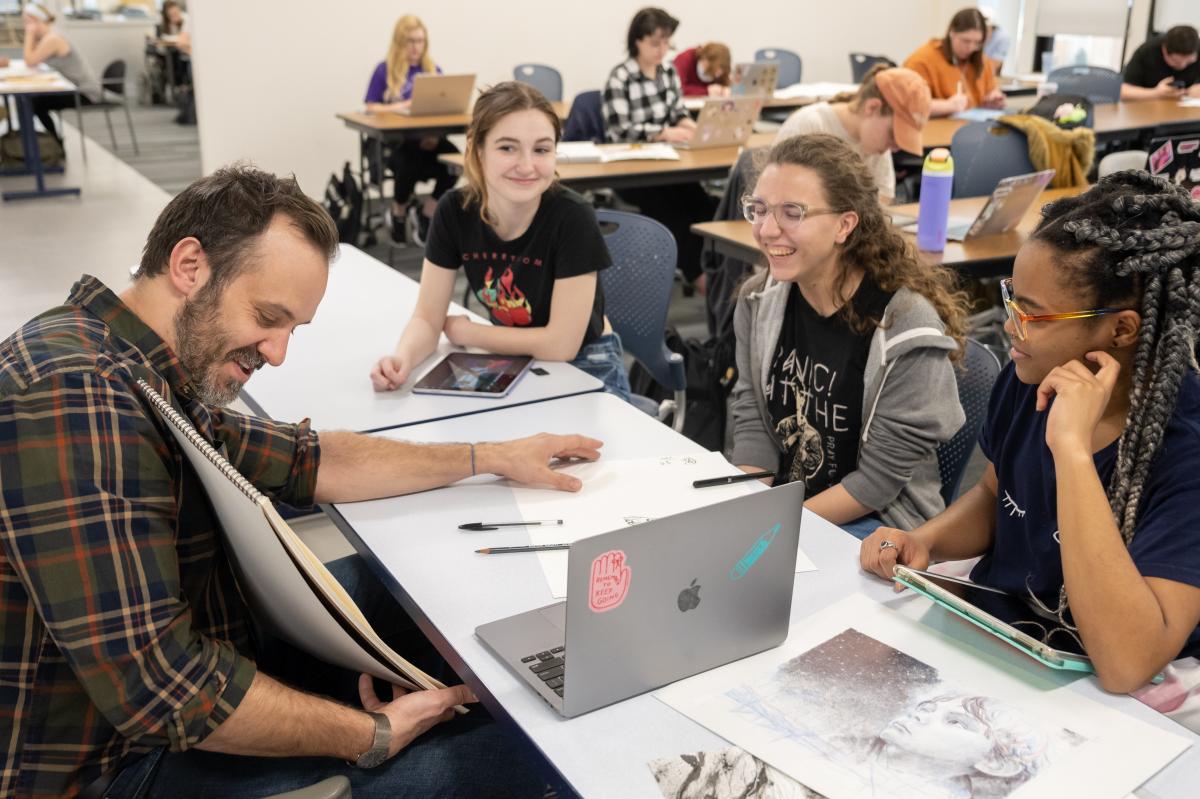 a Kent State professor works with students at a table