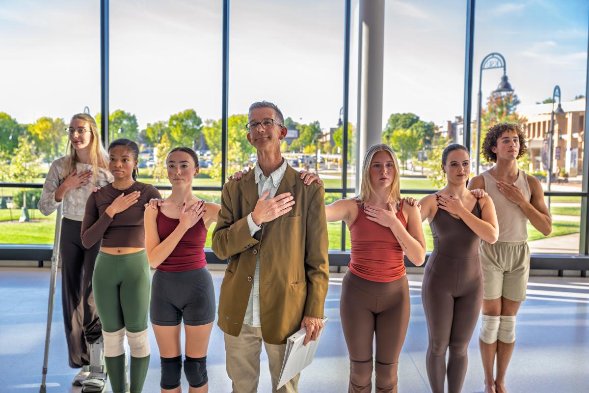 Eric Schmiedl, actor and adjunct professor of theater and dance, and student dance majors take part in the performance of the poem the Pledge.