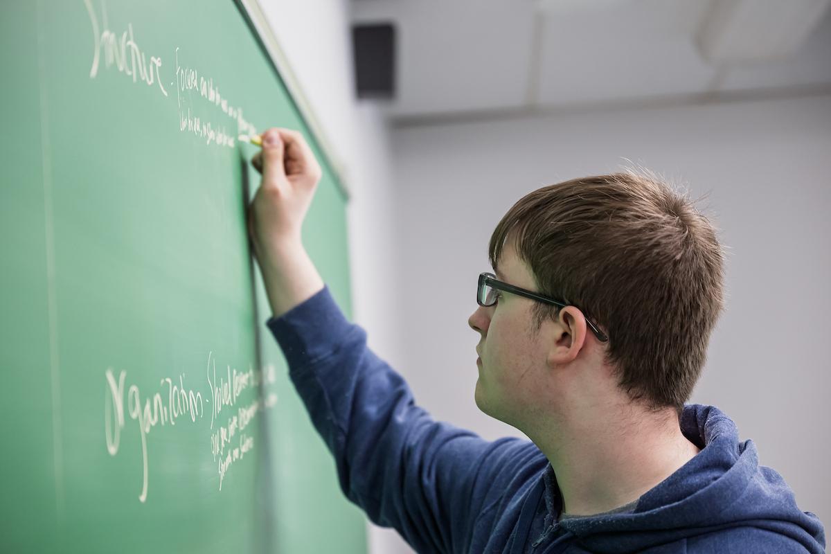 Student writing on a blackboard at ����ֱ�� State University at Ashtabula.