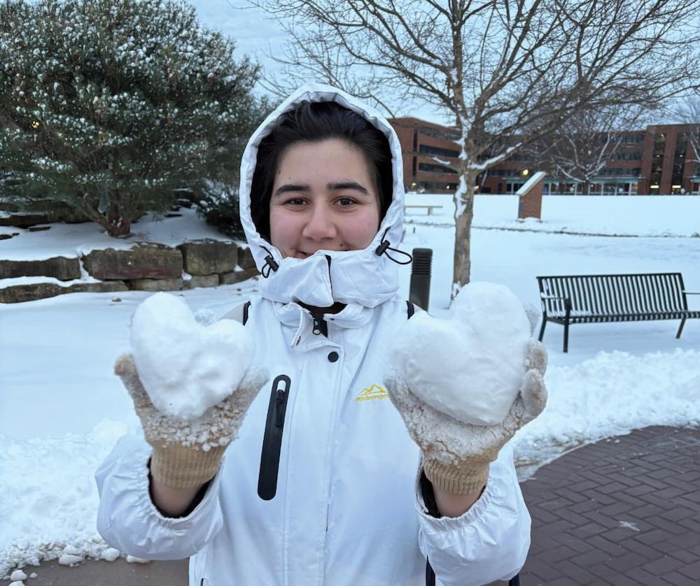 Ayna Tazhiyeva holding two snowballs shaped like hearts