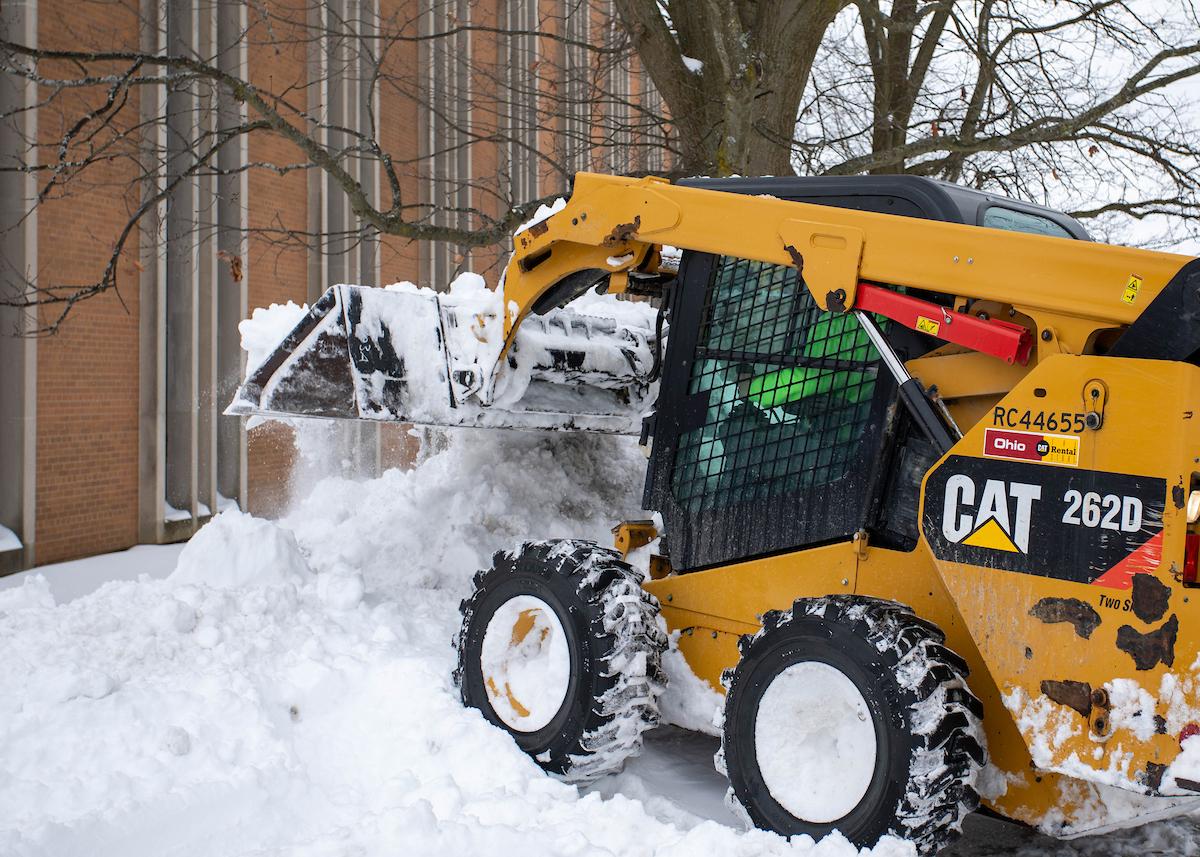 UFM using a CAT tractor to clear snow on Risman Plaza.