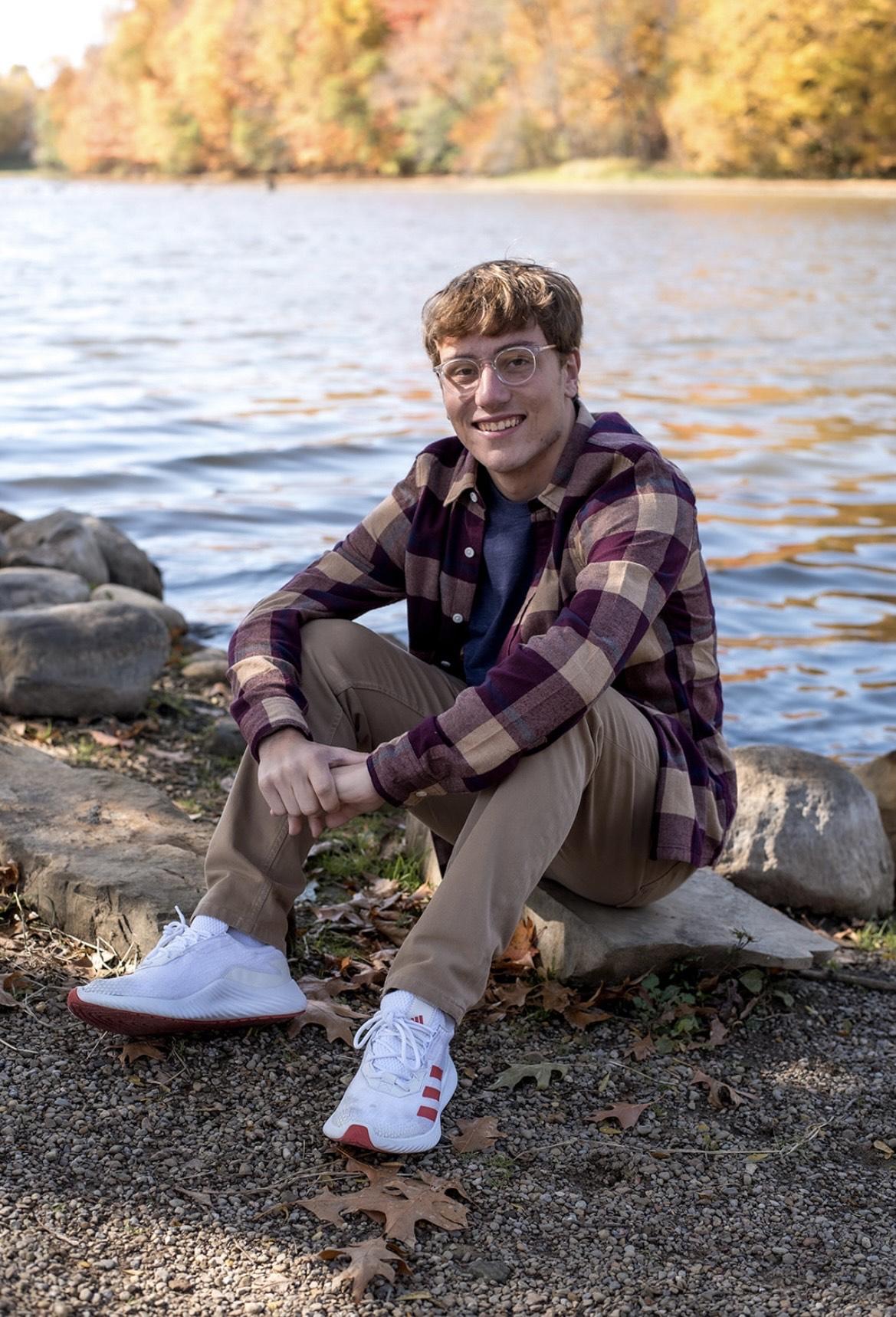 Honors College Student Benny Miller sits near the water.