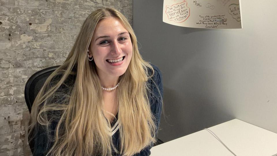 Young alumna sitting at a desk